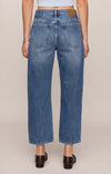 Person wearing blue jeans on a beige background